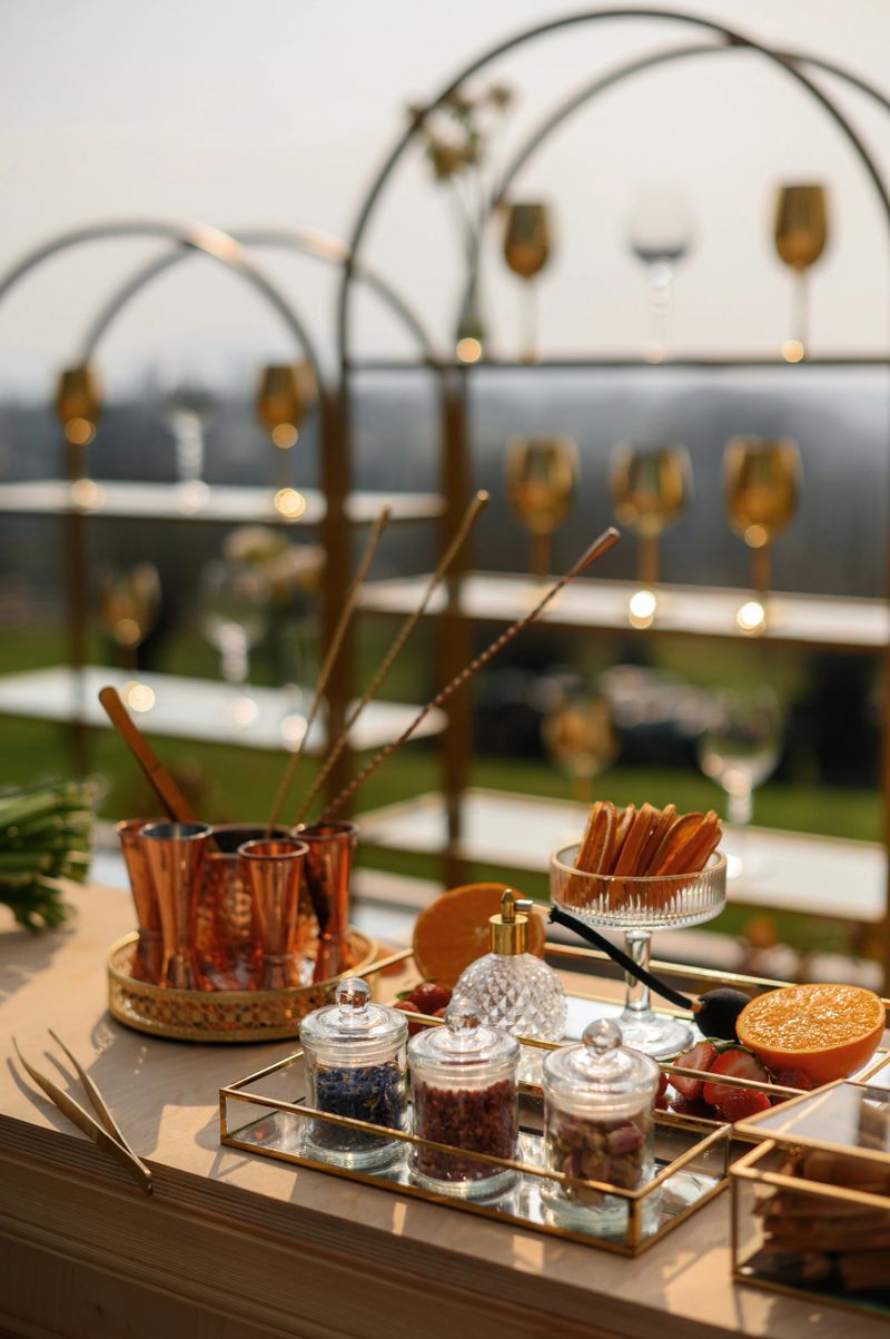 Elegant outdoor cocktail setup with glasses and garnishes.