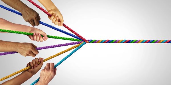 Multiple hands pulling different colored ropes converging into one.