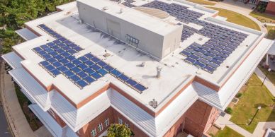Solar panels on the rooftop of a brick building.