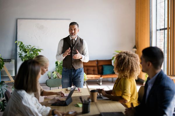 Man presenting to a group in a modern office.