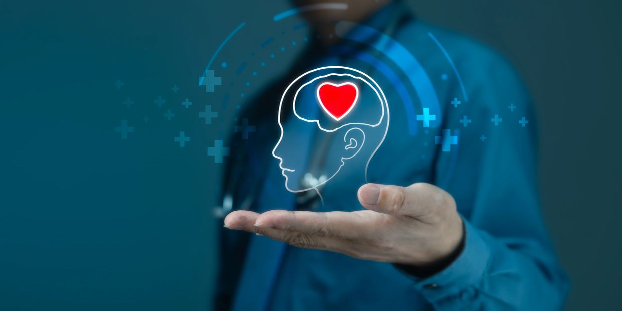 Hand holding a digital brain with a heart symbol inside.