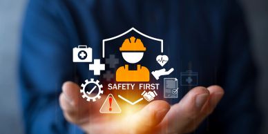 Safety first concept with icons and a worker figure hovering over open hands.