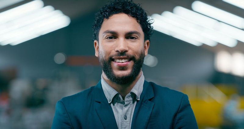 Portrait, man and engineer with smile at warehouse  career pride, about us and inspection. Male person, technician and confident for manufacturing safety, quality assurance and industrial maintenance