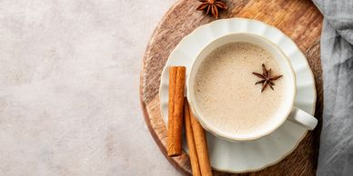 Cup of spiced coffee with cinnamon sticks.
