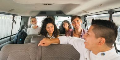 Smiling friends enjoying a ride inside a van.