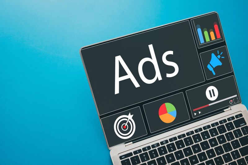 Laptop screen showing a digital advertising (Ads) with analytics charts and targeting icons. Concept for online marketing,social media advertising, marketing analytics,PPC, SEO,and content marketing.