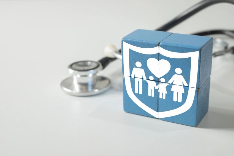 Family health insurance icon on wooden blocks with stethoscope on white background. Concept for medical protection, healthcare policy, family wellness, and affordable health coverage plan.