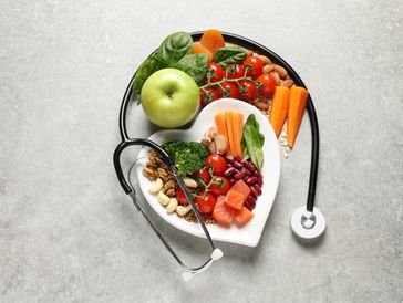 Heart-shaped plate with healthy foods and a stethoscope symbolizing heart health.