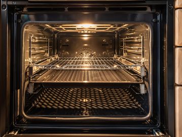 Empty modern oven with light on.