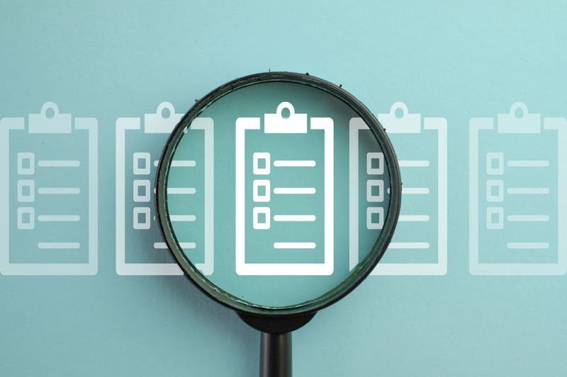 Task Management,Audit,Compliance Verification,Quality Control,Document Inspection concept.,Magnifying Glass Focusing on a Document with Checklist Representing Inspection, Review, and Quality Assurance over blue background.