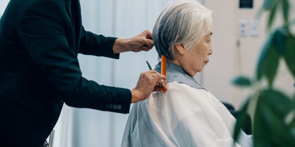 Persona mayor recibiendo un corte de cabello.