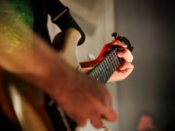 Close-up of a person playing an electric guitar.