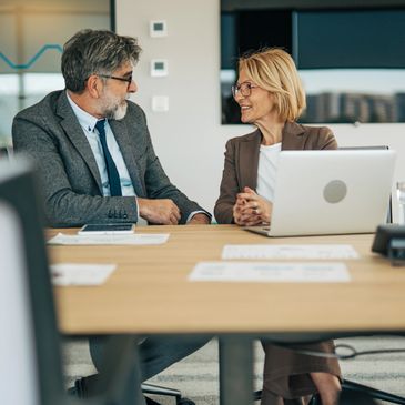 Two professionals engaged in a positive business discussion in an office.