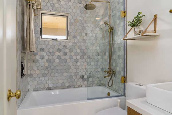 Modern bathroom with hexagon tile shower and glass enclosure.