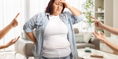 Stressed woman facing blame from others at home.