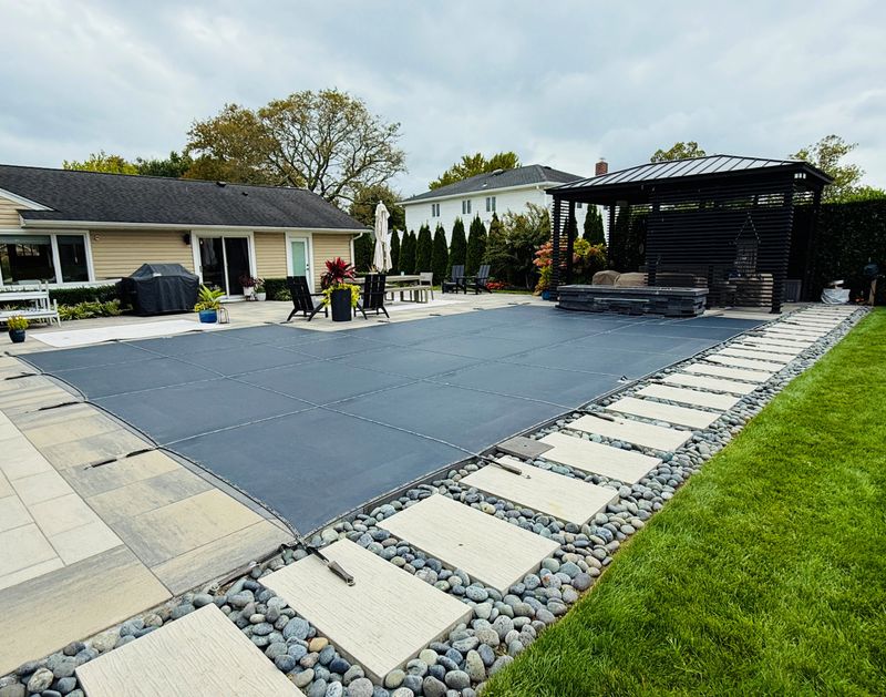 Melting snow, rain drains through. Brass anchors are flush to paver height.  Nice looking and protective pool cover for wintertime.