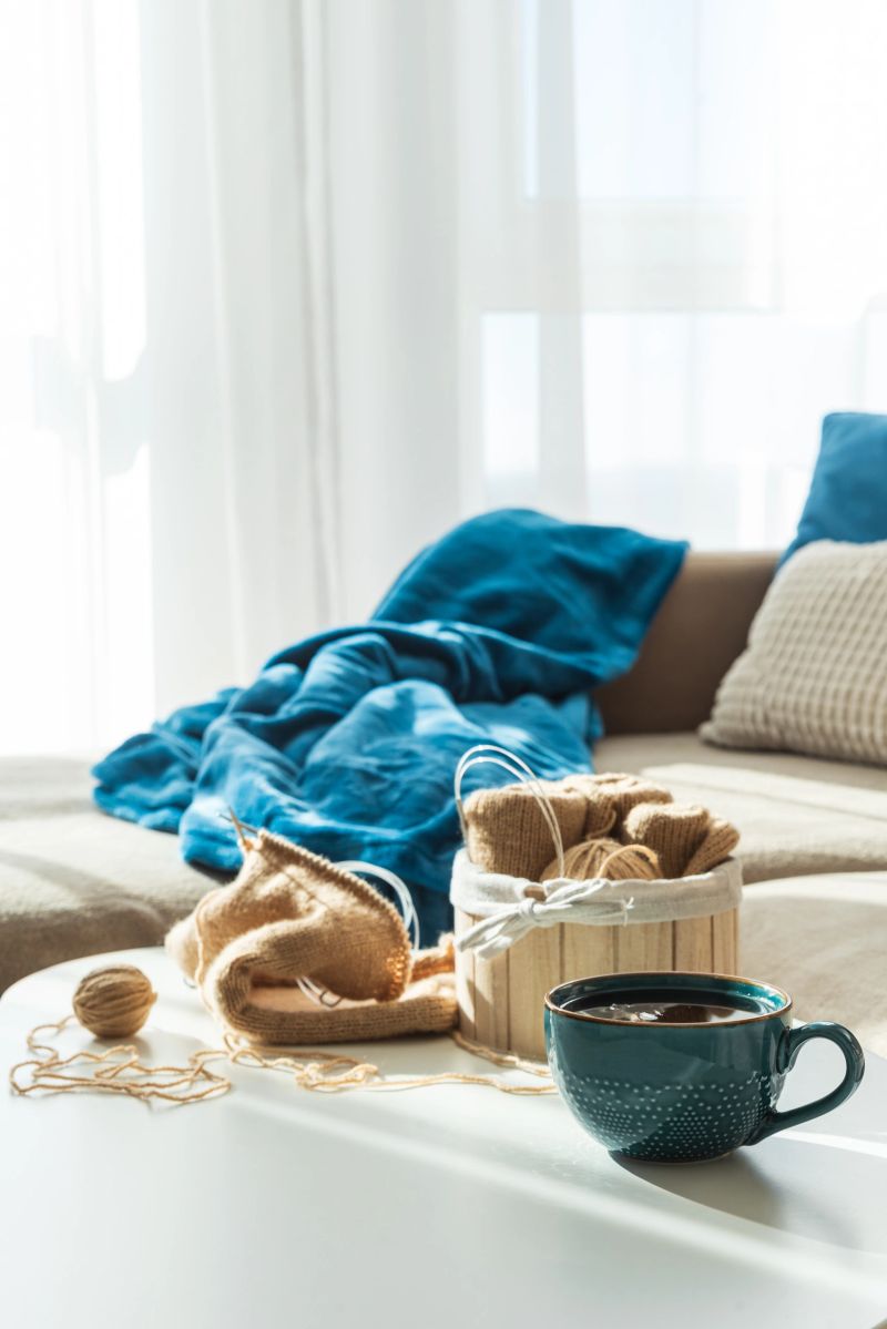 Knitting Setup with Yarn Basket, Mug, and Cozy Couch in Sunlight