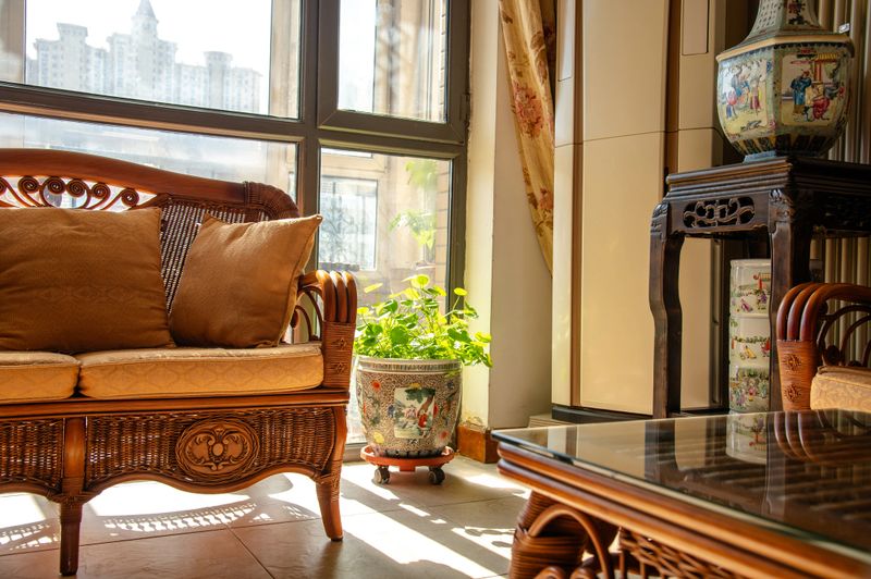 Traditional chinese living room interior featuring rattan furniture and decorative elements bathed in sunlight