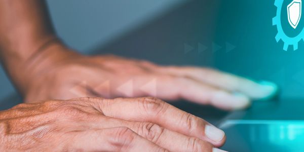 Close-up of hands on a laptop keyboard with digital security icons.