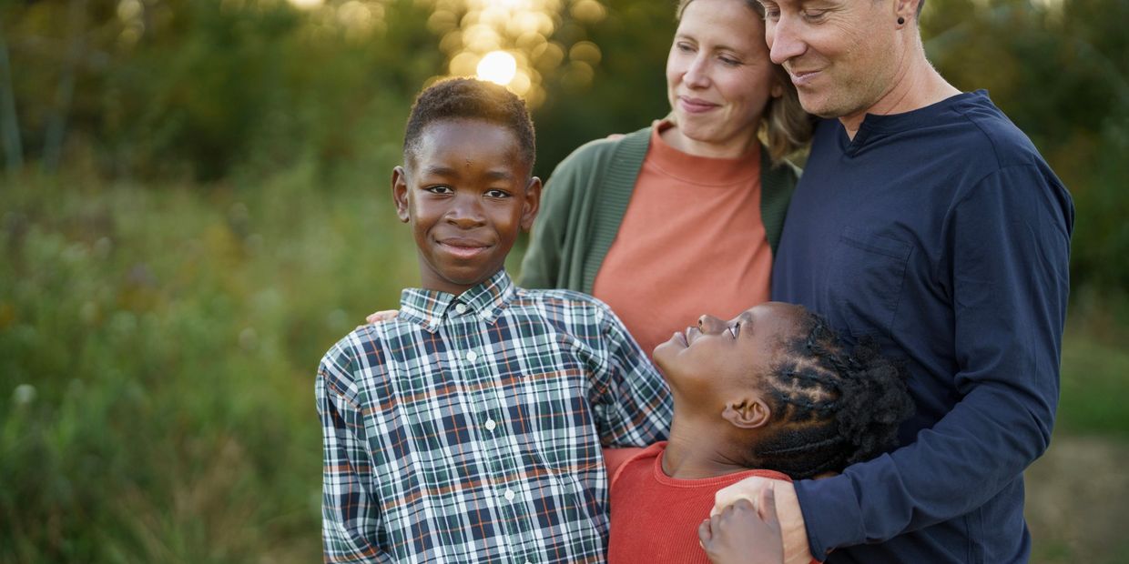 A happy family with two children enjoying a moment outdoors at sunset.