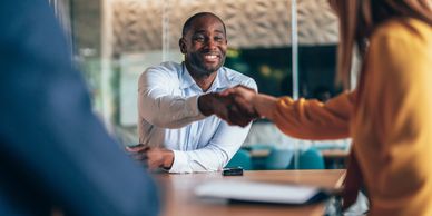 Two people shaking hands in a professional setting.