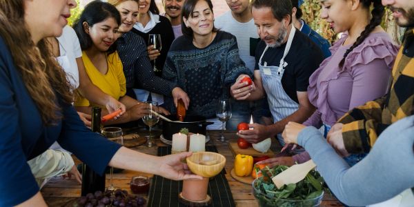 Group of people cooking together and enjoying.