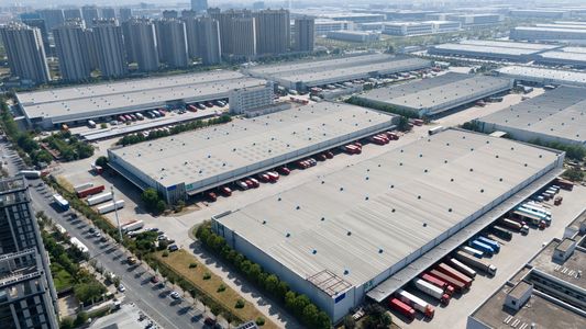 Aerial view of a large industrial warehouse complex with many trucks.