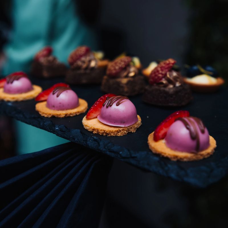 Elegant gourmet desserts on a slate tray. Concept for luxury catering, fine dining, and indulgent celebrations.
