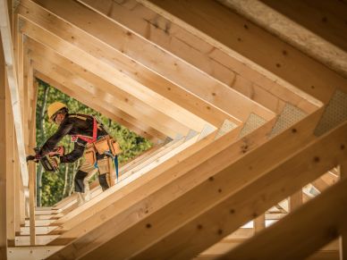 Construction worker nailing wooden beams.