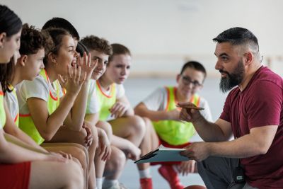 Coach talks to young athletes before a game.