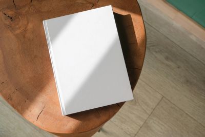 Blank white book on a wooden table.