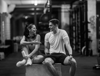 Two friends chatting and smiling at the gym.