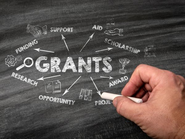 Hand writing grant-related terms on chalkboard.