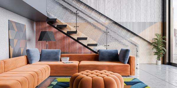 Modern living room with orange sectional sofa and geometric rug under staircase.