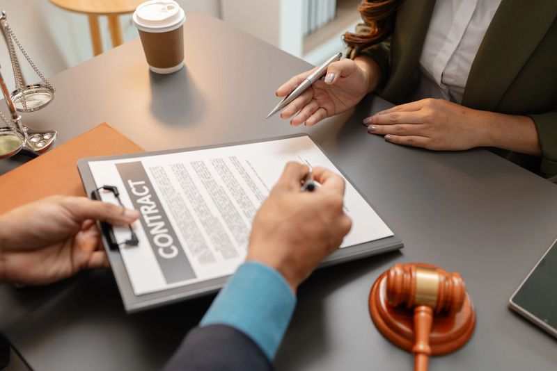 A professional lawyer discusses contract details with a client in the office. Legal consultation and agreement signing concept, showing trust and professionalism in law services and documentation.