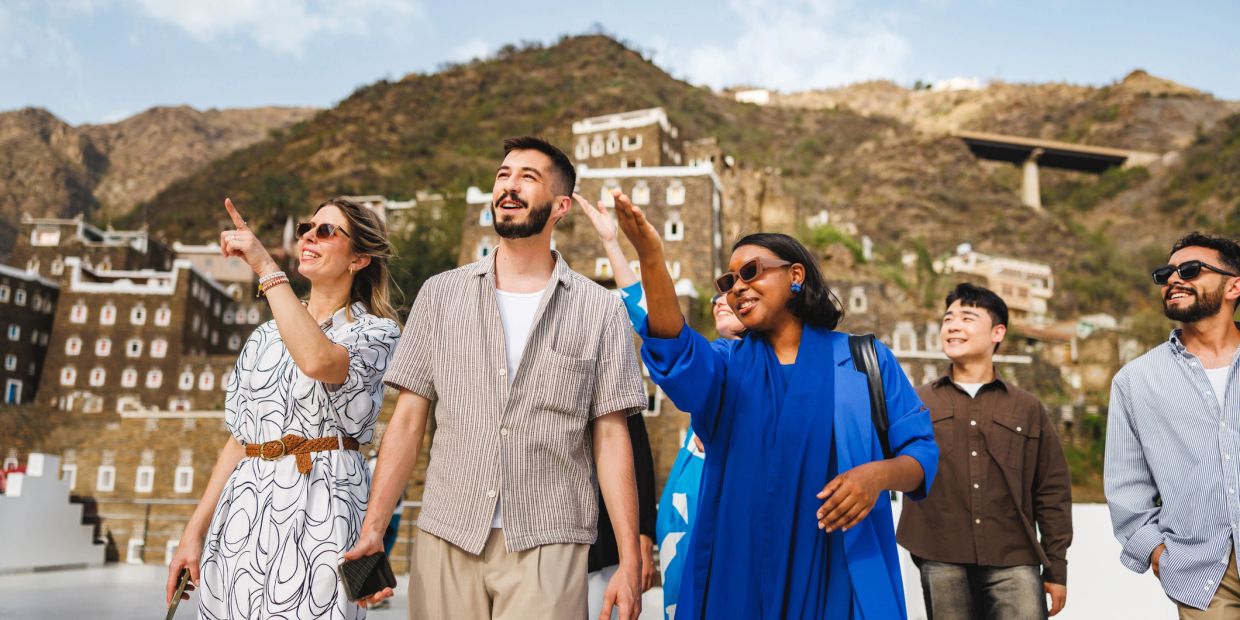 Group of friends sightseeing and enjoying a sunny day in a mountainous village.