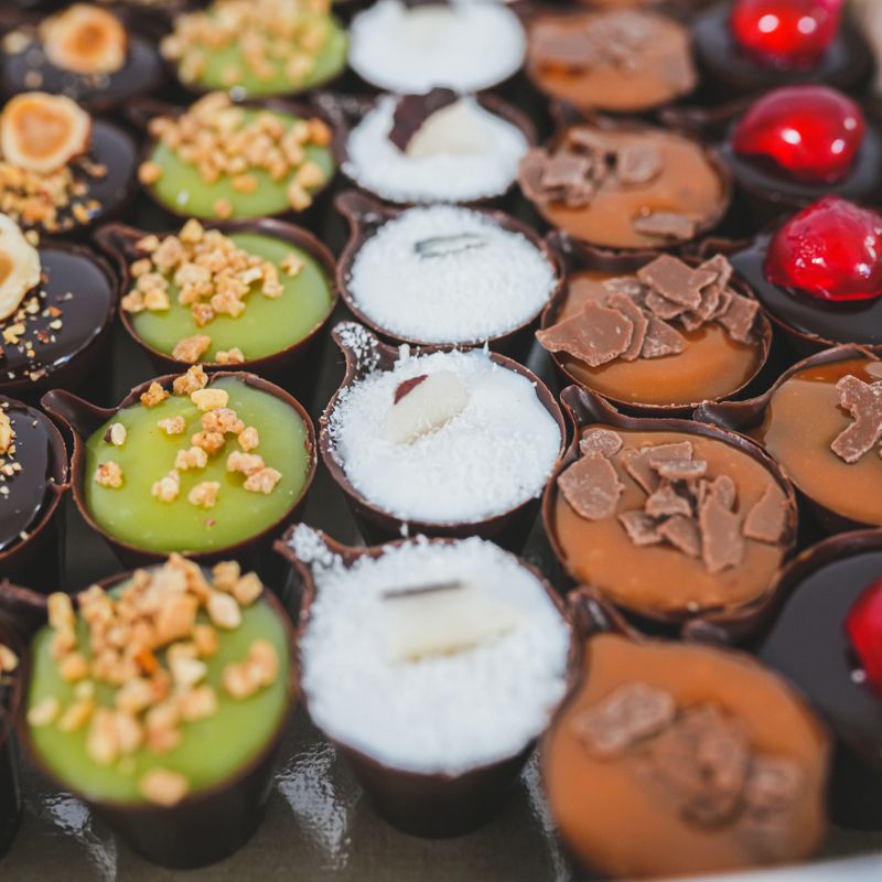 Variation of delicious chocolate mini desserts with various berry and cream fillings