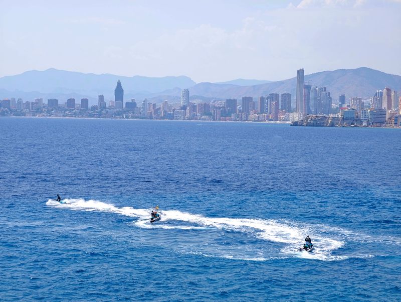 Jetskis racing water, Energetic water sports scene featuring jetskis against picturesque seaside background and skyline