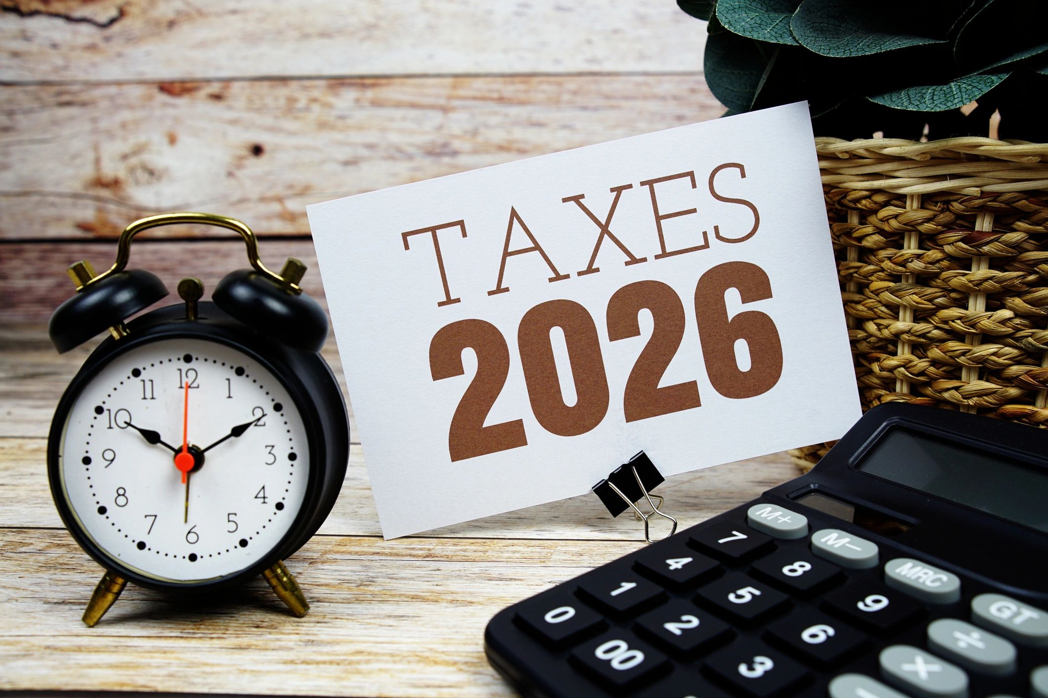 Calculator, clock and tax documents representing tax return deadlines, financial planning and person