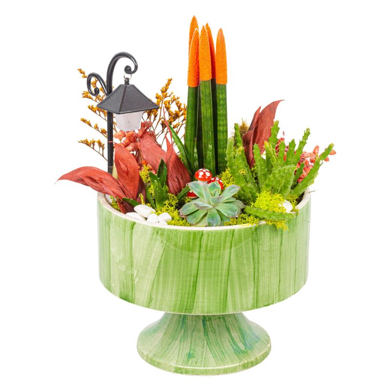 A vibrant decorative plant arrangement with succulents and colorful accents in a green pot, featuring a miniature lamp post.