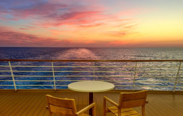 Sunset view over the ocean from a ship deck.