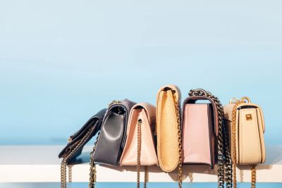 Row of stylish handbags with chain straps.