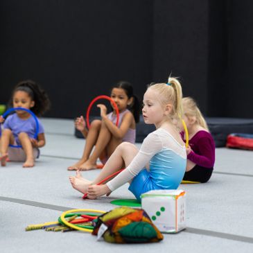 Young girls practicing gymnastics with hoops.