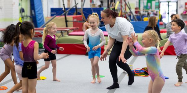 Children and coach playing in a gym.