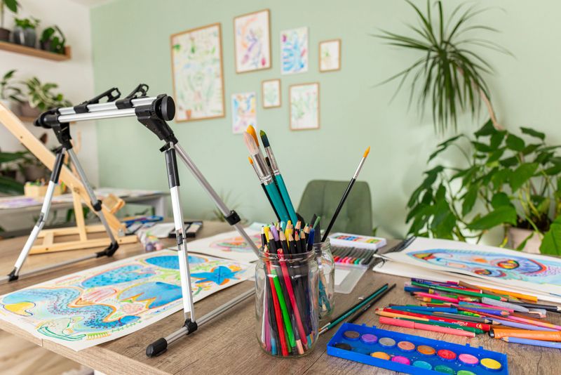 Bright and cozy art space filled with plants and colorful painting supplies inspiring creativity.