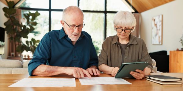 Elderly couple reviewing documents at a table.