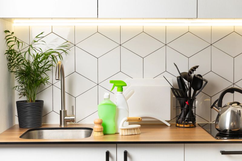 Eco cleaning products against the background of the kitchen. Eco-friendly home cleaning. A bottle of natural detergent surfaces, eco brushes, sponges, and rags. Cleaner concept.Cleaning supplies.
