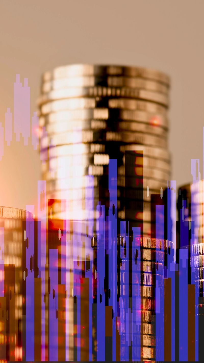 A close-up view of a stack of golden coins superimposed over a blurred, abstract representation of financial data charts and graphs.