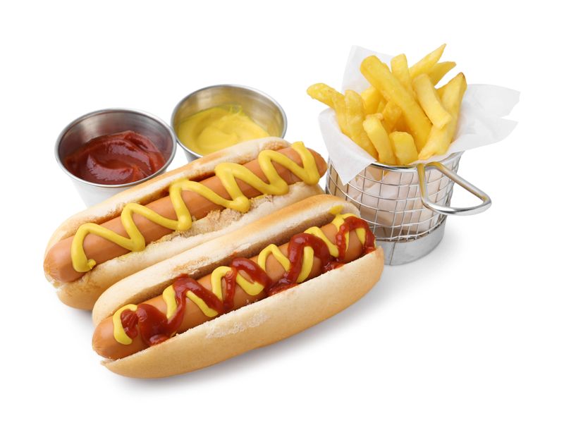 Tasty hot dogs with fries and sauces isolated on white