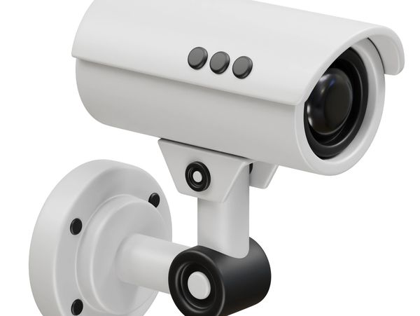 White and black security surveillance camera mounted on a wall.